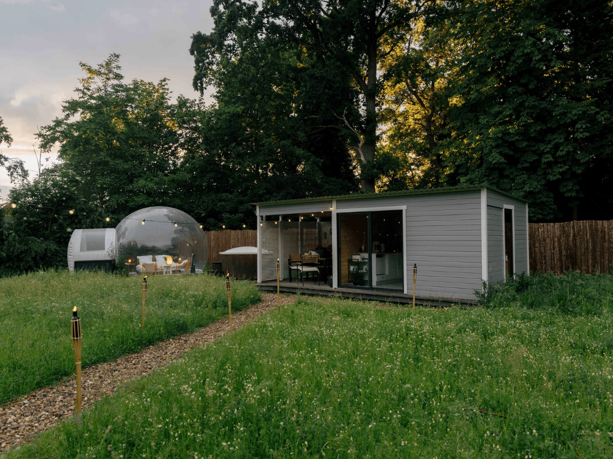 Bubble Zelt mit Whirlpool und Cabin auf einer Blumenwiese – Glamping und Komfort für eine besondere Übernachtung